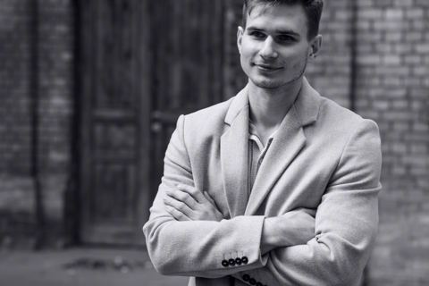Czarno-biały portret w marynarce przy ceglanej ścianie