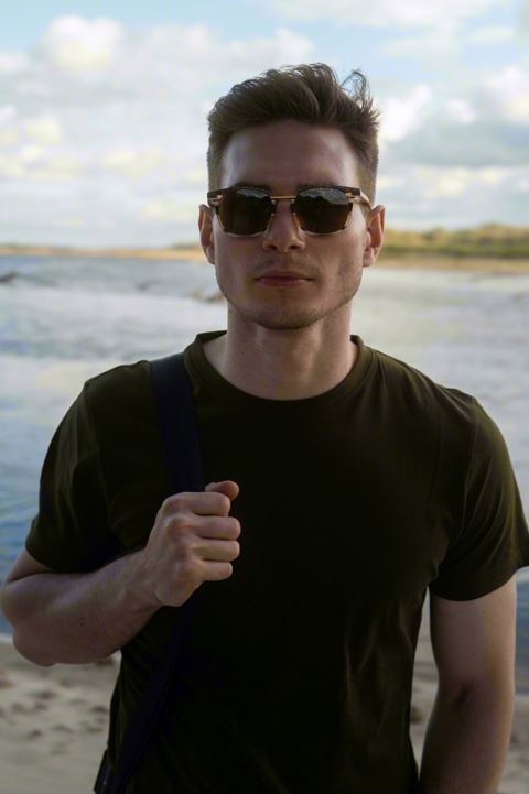 Portret nad morzem, ciemne okulary, czarny t-shirt